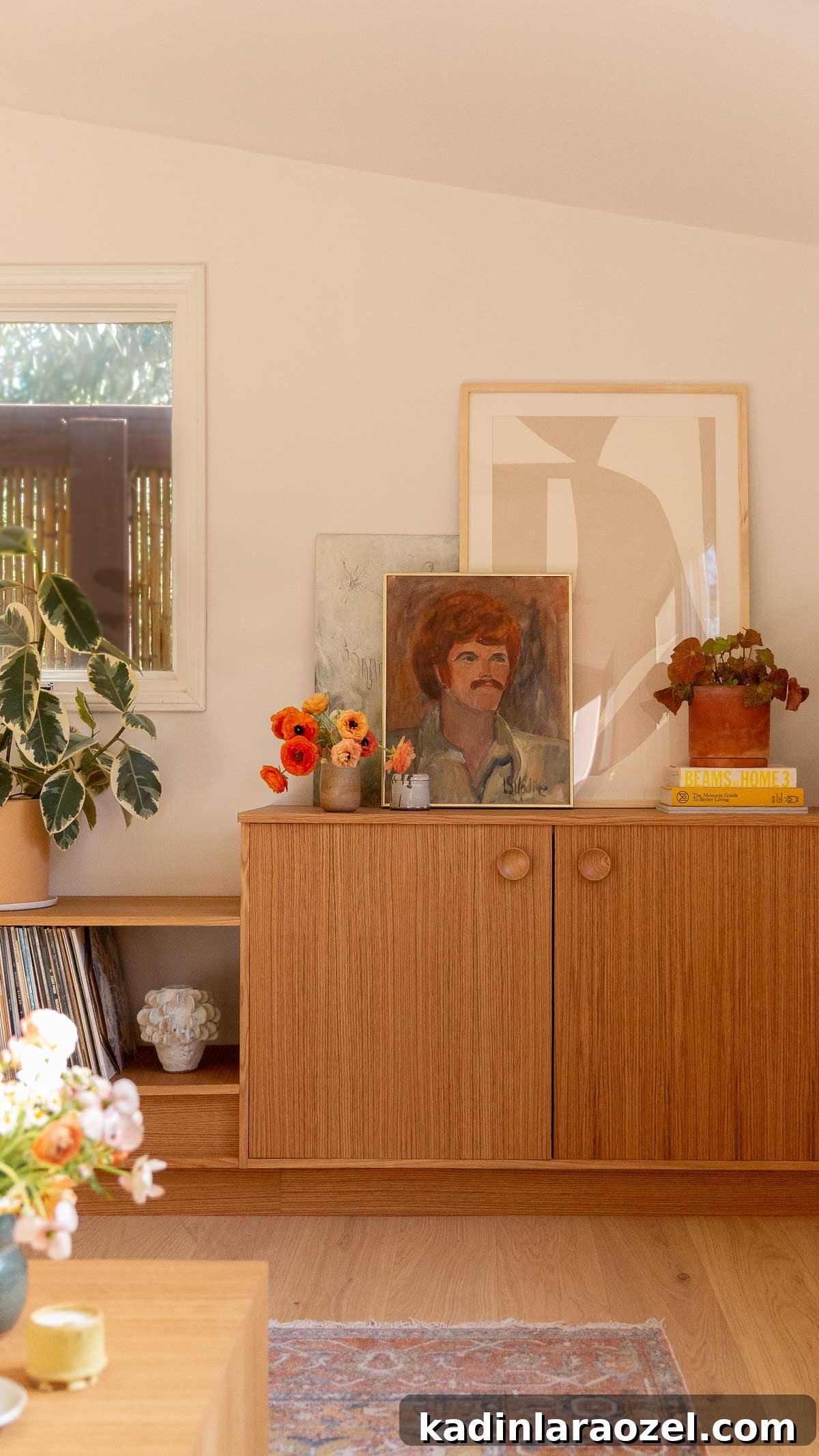 Warm wood cabinetry with artwork and plants in a living room space