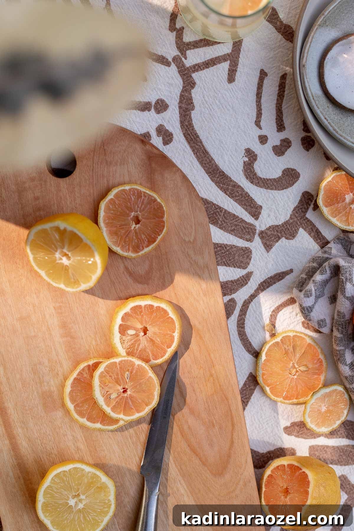 slices lemons on a wood cutting board on a table outside