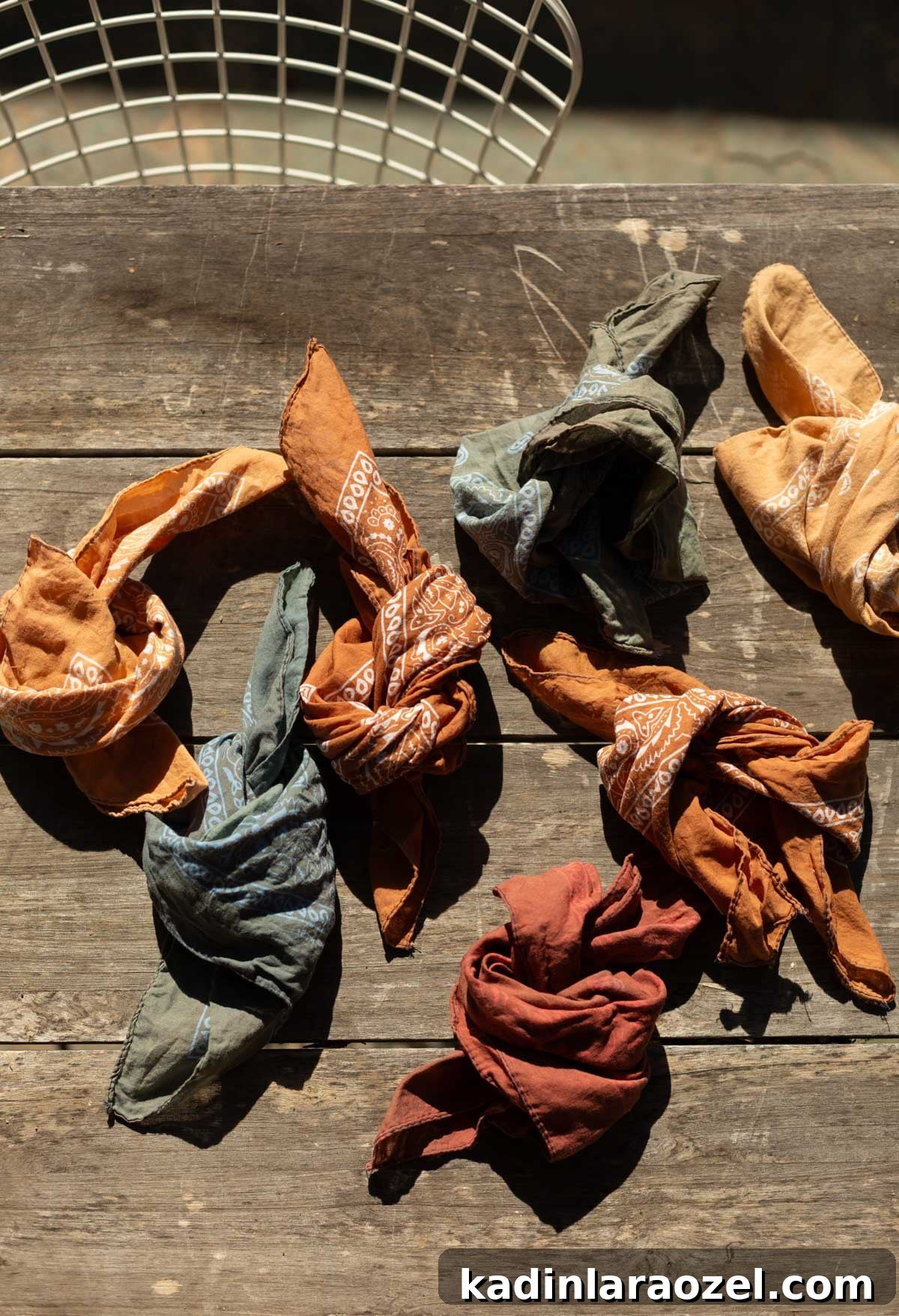 DIY Earth-Tone Bandanas: Stylish Patterns & Sewing Tips 2 earth tone bandanas tied up in knots on an old table outdoors