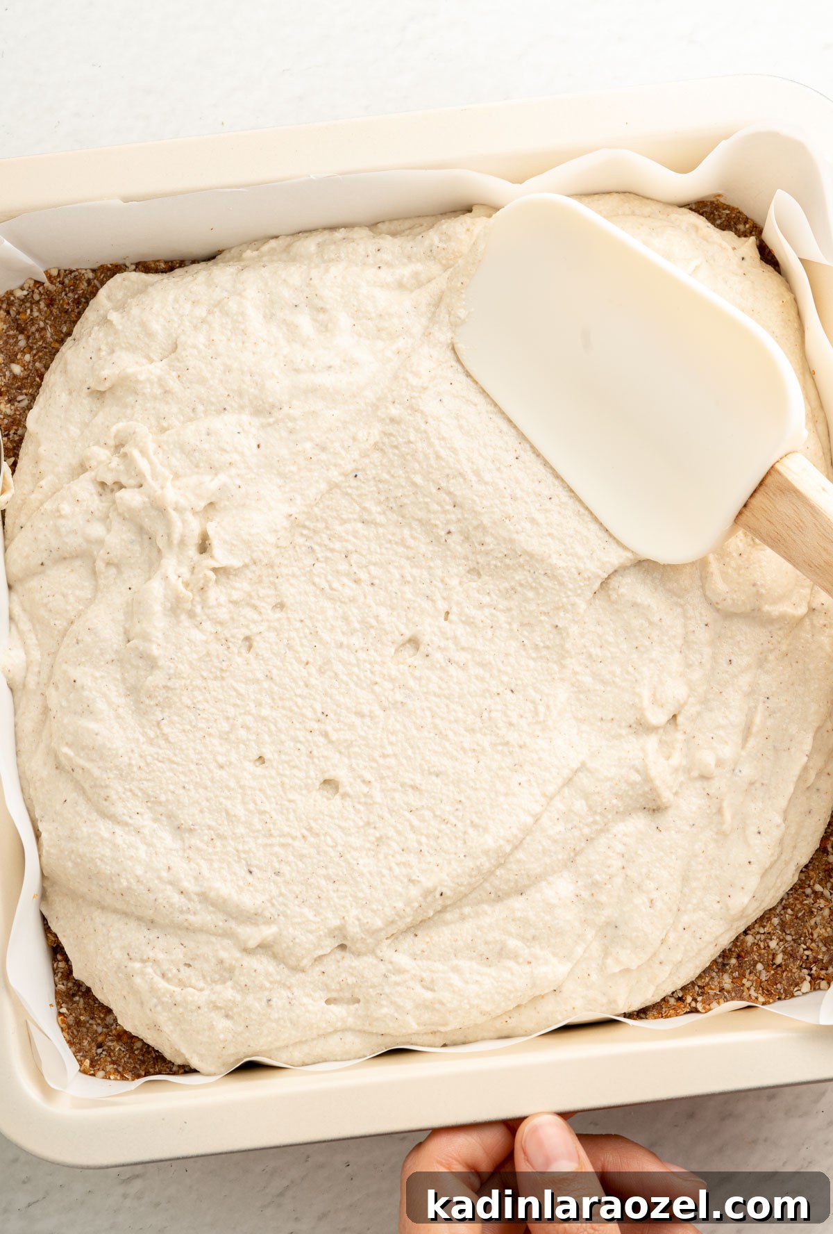 No-Bake Vegan Key Lime Bars — Tangy Creamy Dessert 8 spreading key lime bar filling onto almond crust in a pan